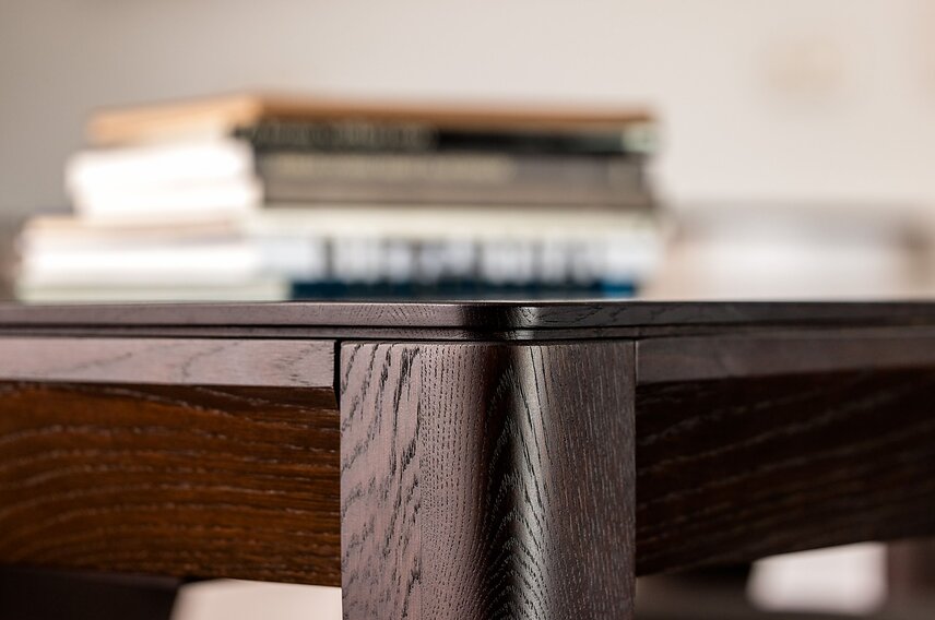 Stół z litego drewna dębowego – zbliżenie na nogę i narożnik blatu w ciemnym kolorze